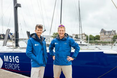Conrad et Mathieu posent en vestes de quart bleu roi devant le bateau à quai 